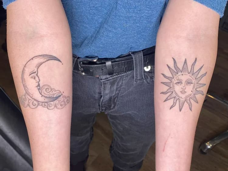 Black and gray moon and sun face tattoo on forearms with decorative scroll work