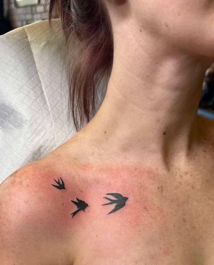 Black and gray neck tattoo with three small bird silhouettes in simple line style